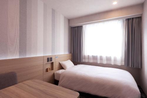 a hotel room with two beds and a window at Kumamoto Washington Hotel Plaza in Kumamoto