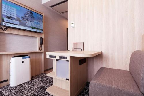 熊本市にある熊本ワシントンホテルプラザのデスク、椅子、テレビが備わる客室です。