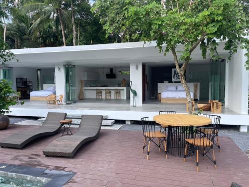 a patio with a table and chairs and a bedroom at KPG Suite Dream in Ban Nua