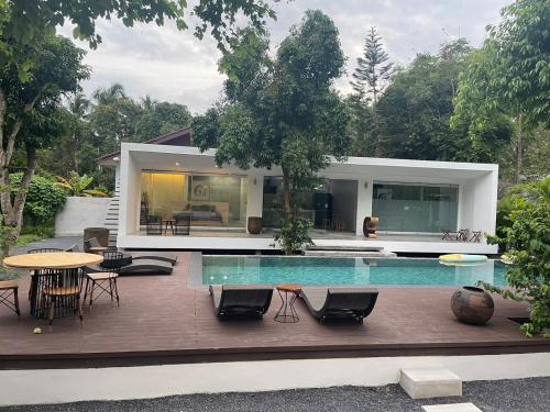 a house with a pool and a table and chairs at KPG Suite Dream in Ban Nua