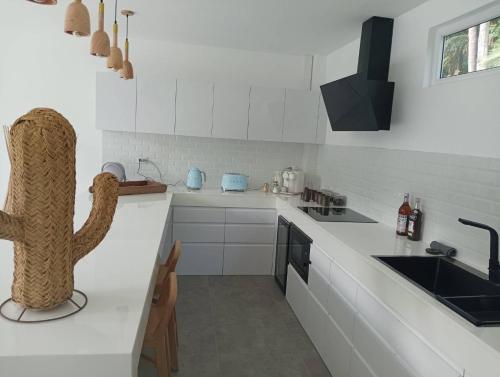 a kitchen with white counter tops and a sink at KPG Suite Dream in Ban Nua