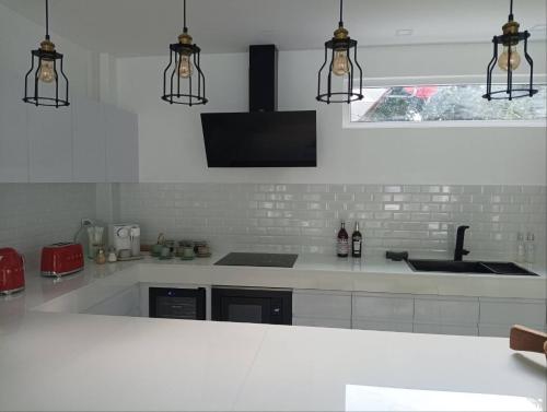 a white kitchen with two lights and a sink at KPG Suite Dream in Ban Nua