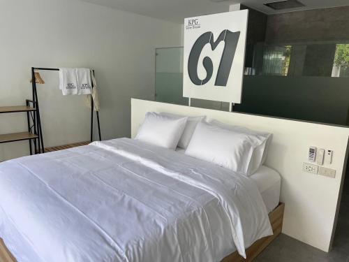 a bedroom with a large white bed with white pillows at KPG Suite Dream in Ban Nua