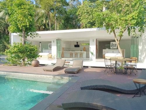 a pool with chairs and a table and a house at KPG Suite Dream in Ban Nua