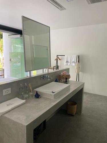 a bathroom with a white sink and a mirror at KPG Suite Dream in Ban Nua