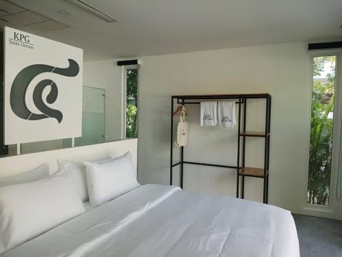 a bedroom with a large white bed and a towel rack at KPG Suite Dream in Ban Nua