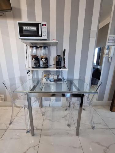 a glass table with a microwave on a shelf at B&B Pescara Centro Luxury Suite in Pescara