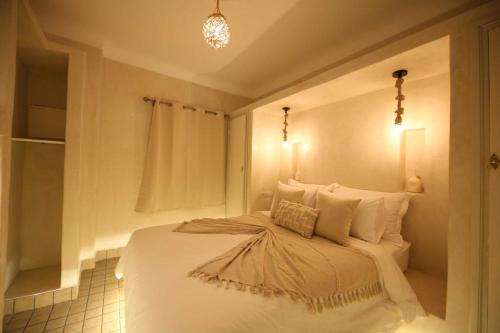 - une chambre avec un lit blanc éclairé dans l'établissement Riad Oum B&B, à Marrakech