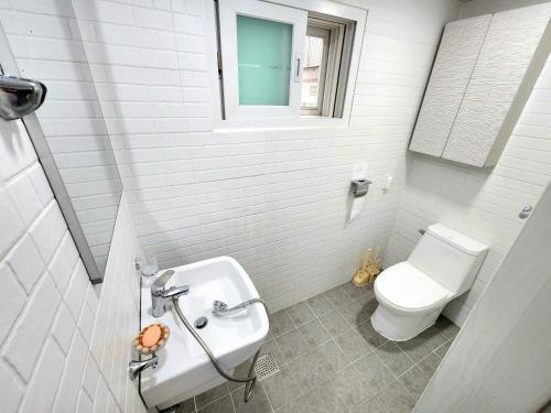 Baño blanco con aseo y lavamanos en Hong dae, 3bed room, 2toilet, full optioned, entire house en Seúl