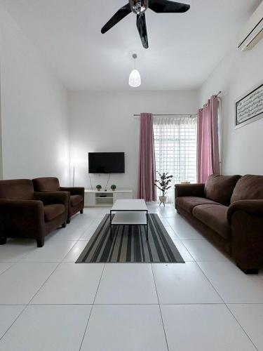 uma sala de estar com 2 sofás e uma ventoinha de tecto em Cosy House For Family Or Group In Bukit Beruang Melaka em Kampong Pengkalan Batu
