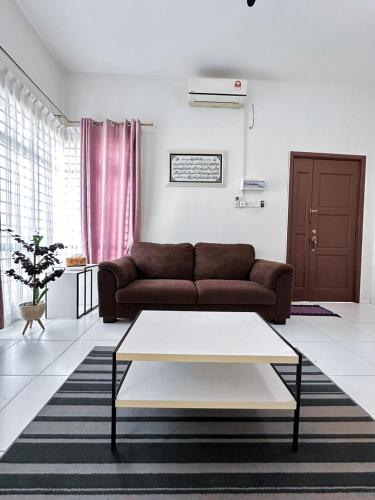 a living room with a couch and a coffee table at Cosy House For Family Or Group In Bukit Beruang Melaka in Kampong Pengkalan Batu