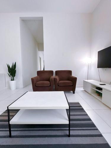 a living room with a couch and a coffee table at Cosy House For Family Or Group In Bukit Beruang Melaka in Kampong Pengkalan Batu