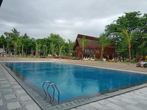 a swimming pool in front of a building at Wyndham Garden Yogyakarta Hotel Conference & Action Park in Sleman