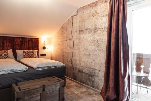 a bedroom with a bed and a brick wall at PHILSON Apartments in Saalbach Hinterglemm