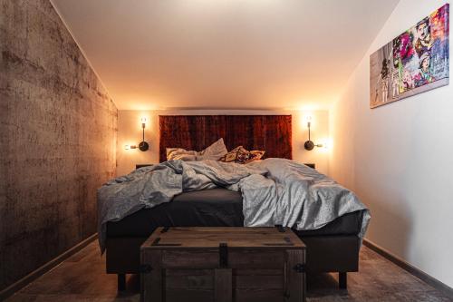 a bedroom with a large bed with a wooden table at PHILSON Apartments in Saalbach Hinterglemm