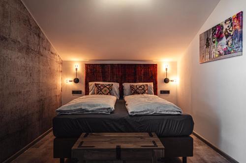 a bedroom with a bed with a wooden headboard at PHILSON Apartments in Saalbach Hinterglemm