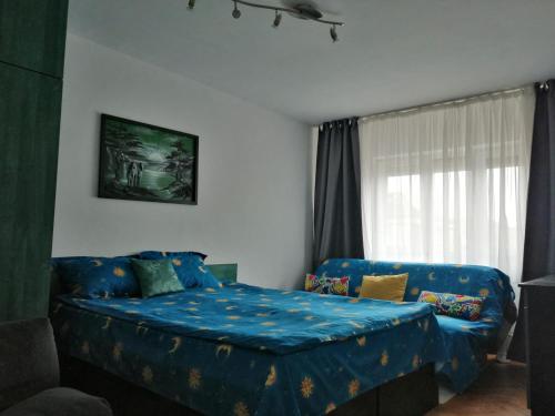 - une chambre avec un lit bleu et un canapé dans l'établissement Jorali, à Oradea