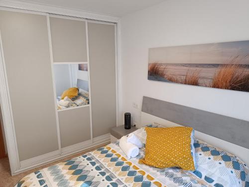 sypialnia z łóżkiem i obrazem na ścianie w obiekcie Apartamento Velázquez w Maladze