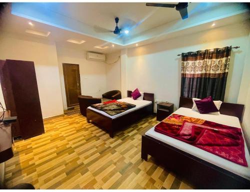 Habitación con 2 camas y sofá. en Hotel Royal City, Chakchaka, WB en Kuch Bihār
