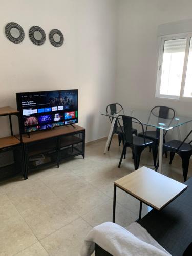 a living room with a tv and a table and chairs at Bohemio in Málaga