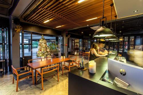 a dining room with a table and a christmas tree at Loft Mania Boutique Hotel in Chumphon