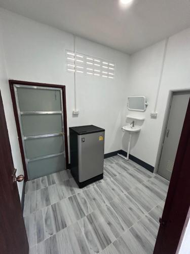 um quarto vazio com um lavatório e uma porta em หอพักนฤมล em Bung Kan