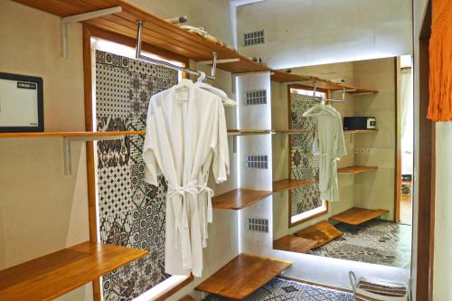 a room with shelves and a wall with a robe at Villa Merdu Ubud in Ubud