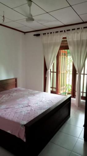 um quarto com uma cama num quarto com janelas em Praveen villa em Beruwala