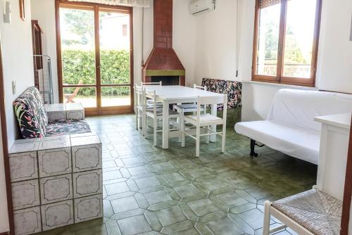 ein Wohnzimmer mit einem Tisch, Stühlen und einem Kamin in der Unterkunft M085 - Marcelli, trilocale con giardino al Residence MARE VERDE in Marcelli