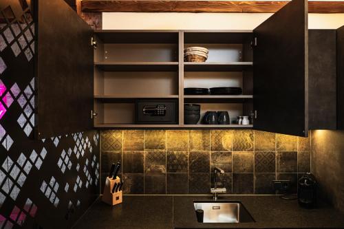 a kitchen with black cabinets and a sink at PHILSON Apartments in Saalbach Hinterglemm