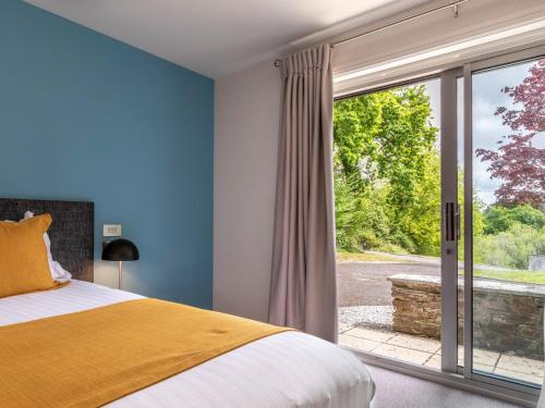 a bedroom with a bed and a large window at 3 Bed in St. Mellion 87716 in St Mellion