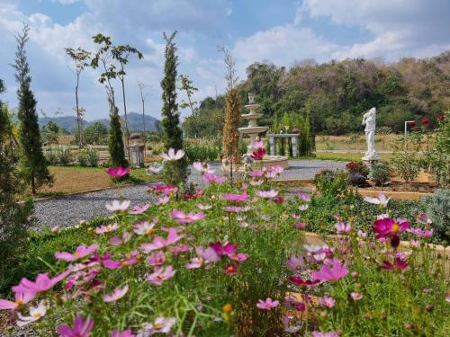 a garden with pink flowers and a statue at Maryland Khaoyai Annapolis Pool Villa in Ban Nong Song Hong