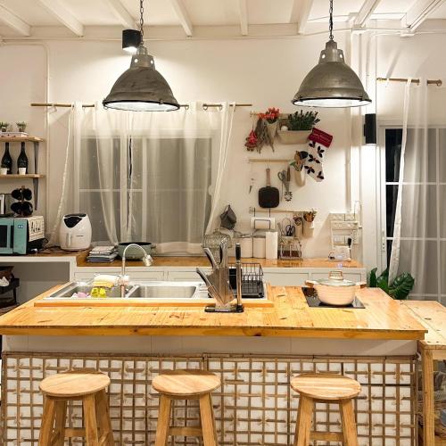 a kitchen with a counter with stools and a sink at Maryland Khaoyai Annapolis Pool Villa in Ban Nong Song Hong