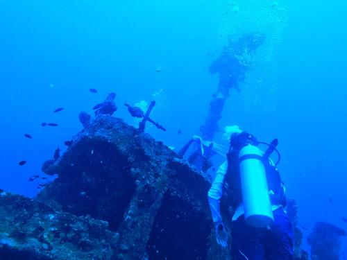 a group of people standing on a wreck in the ocean at Manta Sea View Himandhoo in Himandhoo 