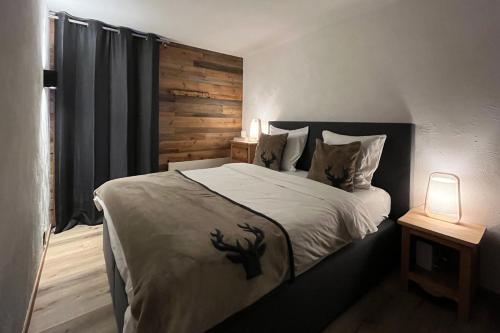a bedroom with a bed with a wooden wall at Les Cerfs - Appartement & Studio - ANZERE in Anzère