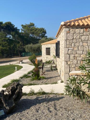 a stone building with a pathway next to a house at AGROTOPIA Guesthouses in Theologos