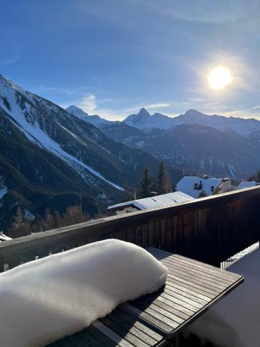 a pillow sitting on a table on a balcony with mountains at Chalet Wiesen in Davos