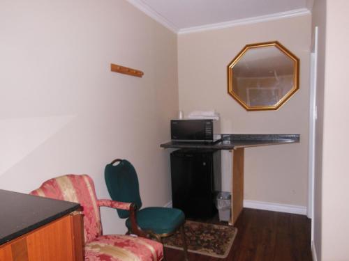 a room with a desk and a chair and a mirror at Kent Motel in Chatham