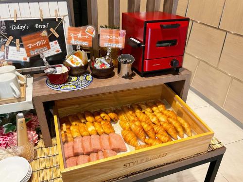 a table with a box of sausage and other food at Tabino Hotel Kurashiki Mizushima in Kurashiki