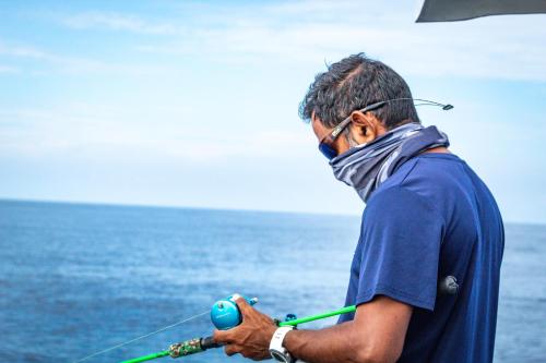 a man wearing a mask holding a fishing rod at Manta Sea View Himandhoo in Himandhoo 