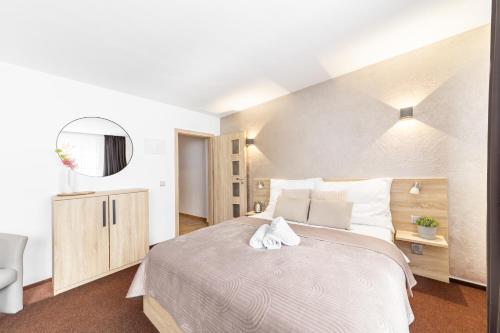 a bedroom with a large bed and a mirror at Penzion Pepovka in Filipovice