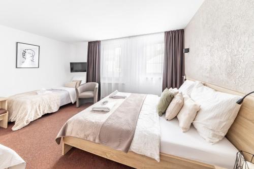 a hotel room with two beds and a chair at Penzion Pepovka in Filipovice