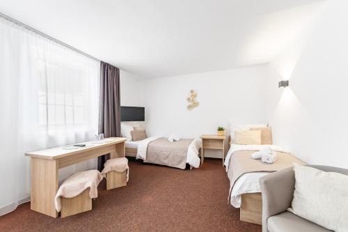 a hotel room with two beds and a couch at Penzion Pepovka in Filipovice