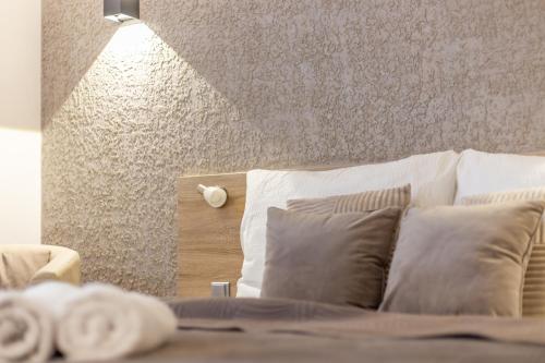 a bedroom with a bed with pillows and a wall at Penzion Pepovka in Filipovice