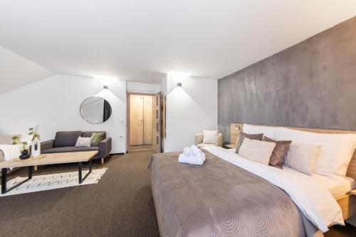a bedroom with a large bed and a couch at Penzion Pepovka in Filipovice