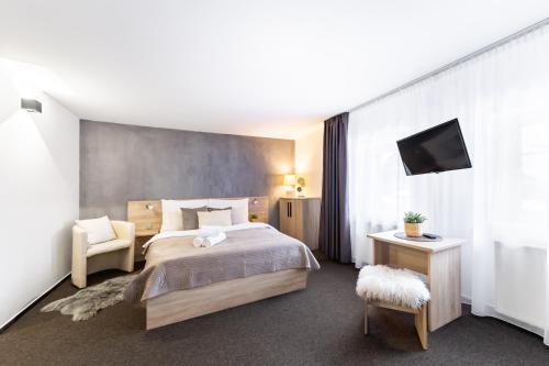 a hotel room with a bed and a television at Penzion Pepovka in Filipovice