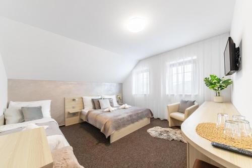 a bedroom with two beds and a desk with a computer at Penzion Pepovka in Filipovice