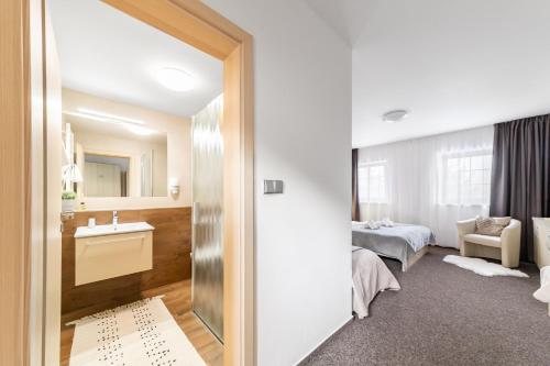 a hotel room with a sink and a bedroom at Penzion Pepovka in Filipovice