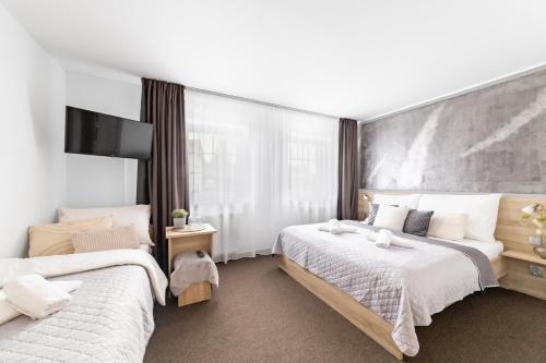 a bedroom with two beds and a large window at Penzion Pepovka in Filipovice