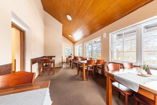 a dining room with tables and chairs and windows at Penzion Pepovka in Filipovice